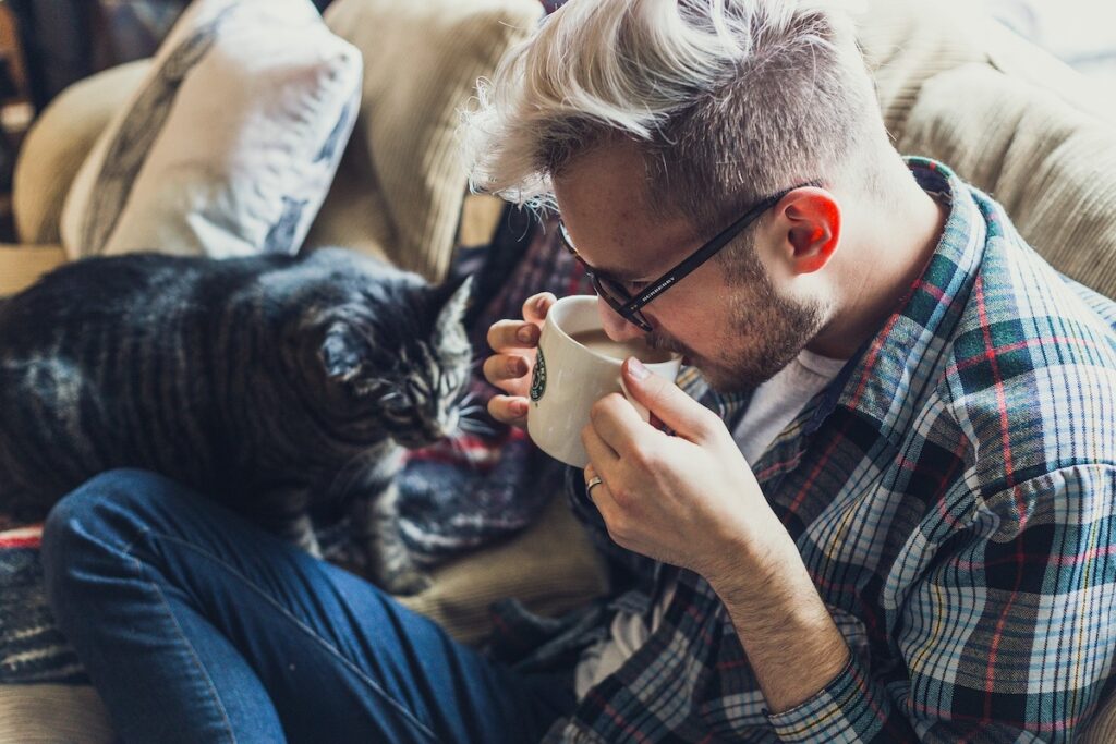 Uomo beve caffè sul divano