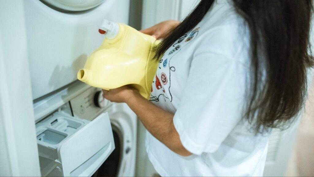 donna mette in lavatrice l'aceto