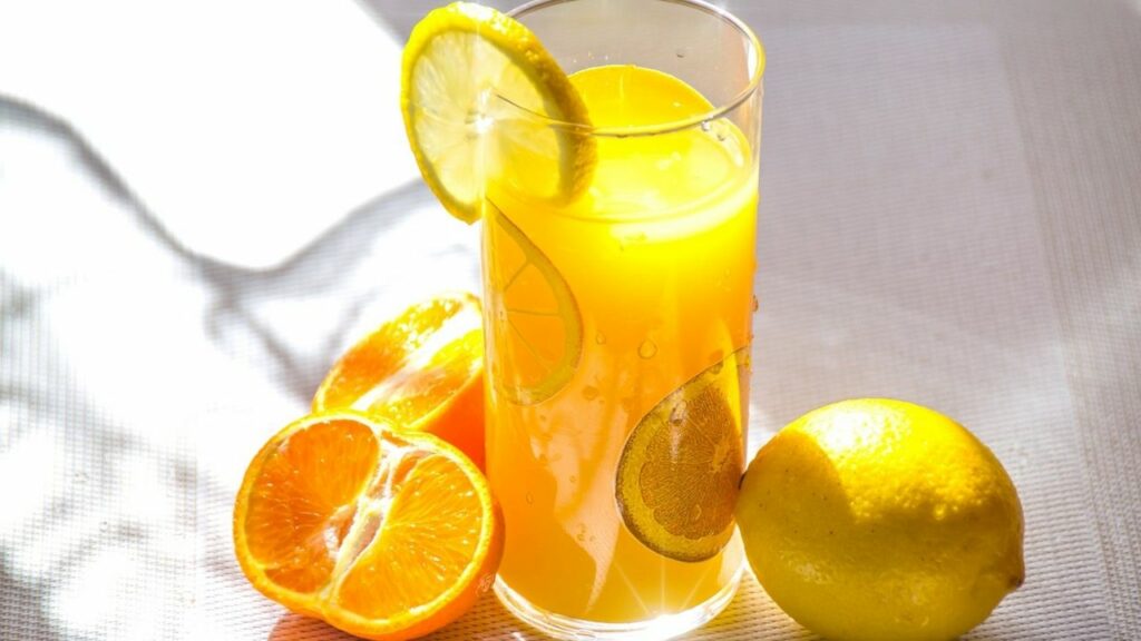 succo di limone in un bicchiere con i limoni attorno