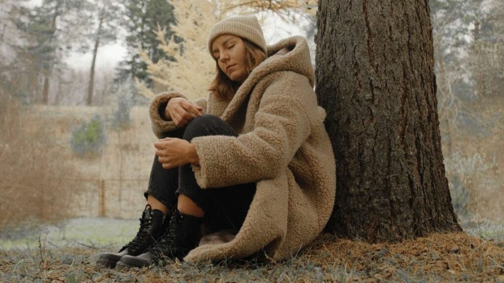 donna nel bosco con cappotto di lana